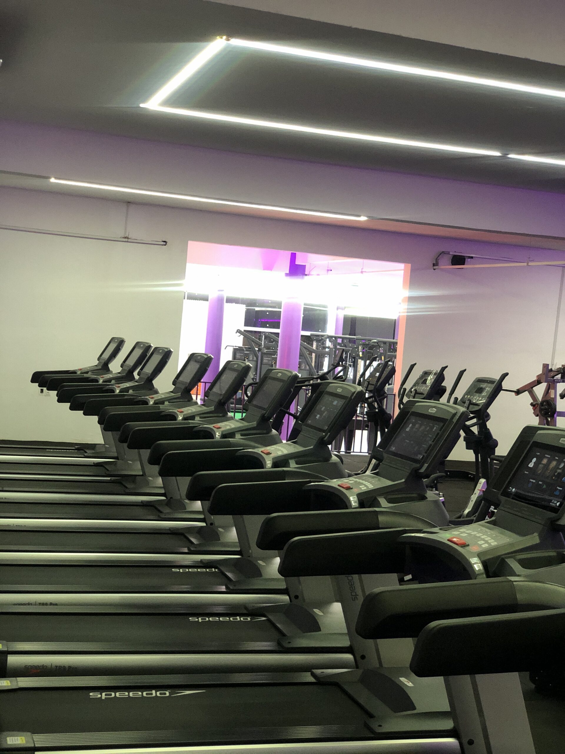 Área de musculação iluminada em roxo da Duxfit
